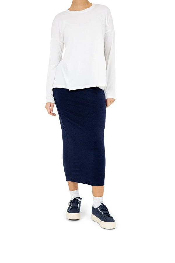 Woman modeling Snoga Athletics navy athletic skirt and white long sleeve top