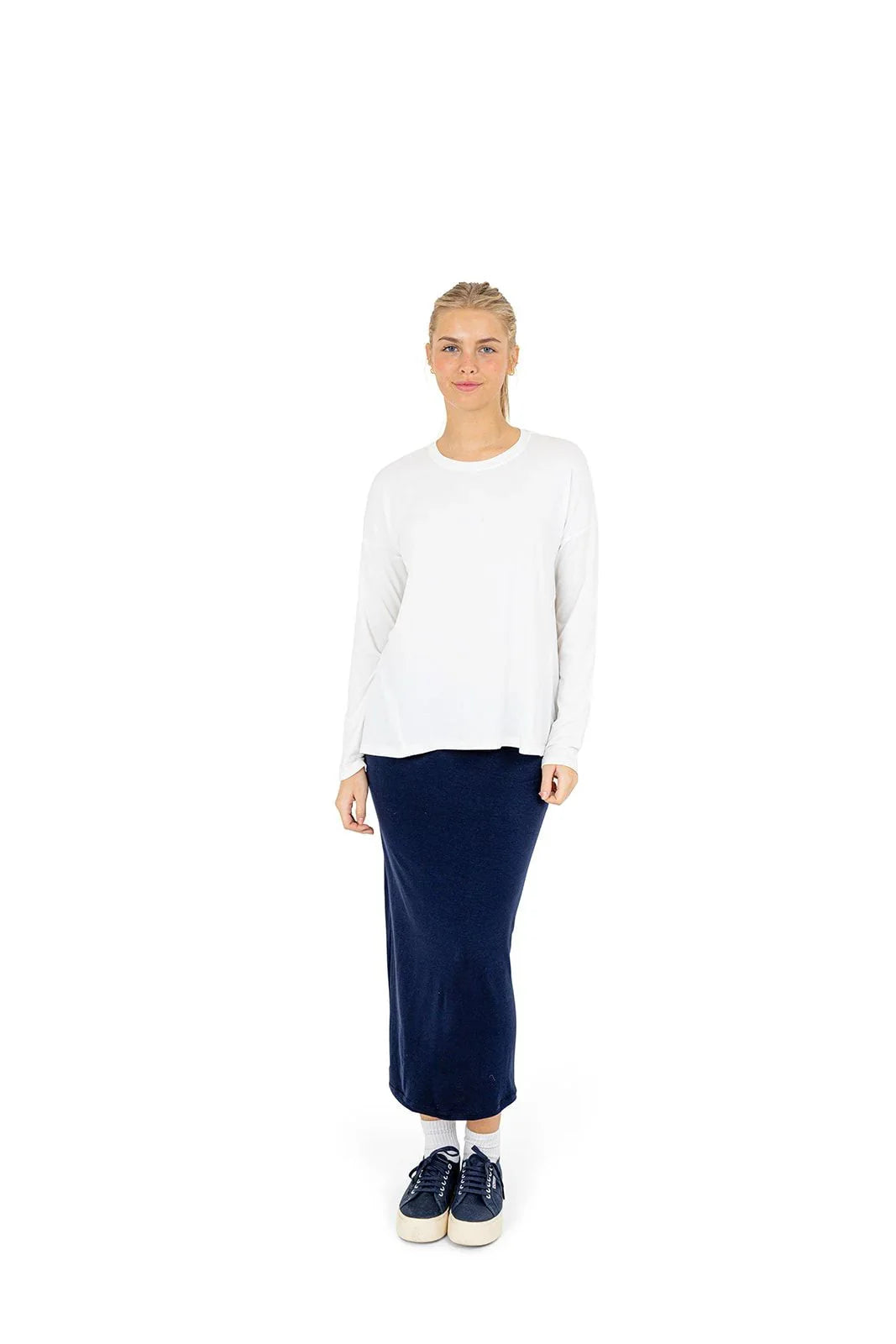 Woman wearing Snoga Athletics navy athletic skirt and white long sleeve top