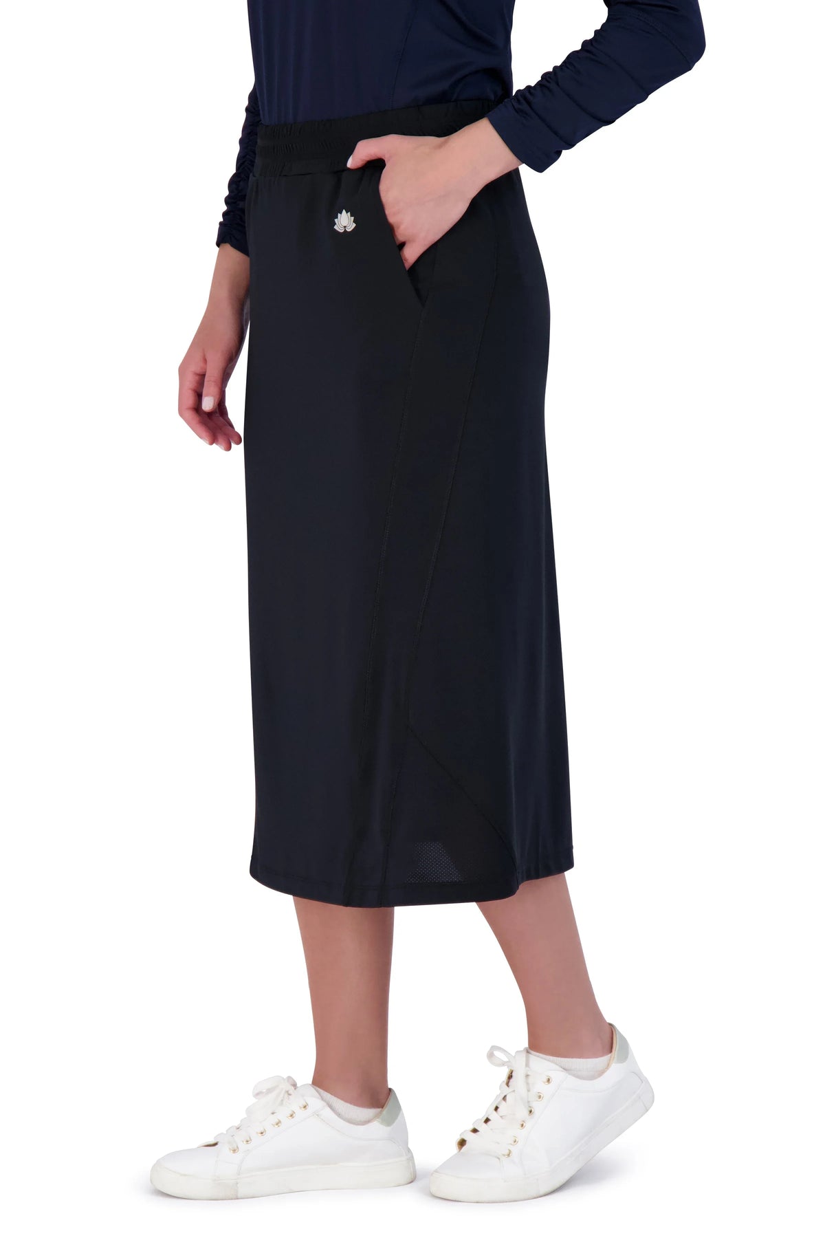 Snoga Athletics black modest travel skirt with pockets, worn by a woman, side view
