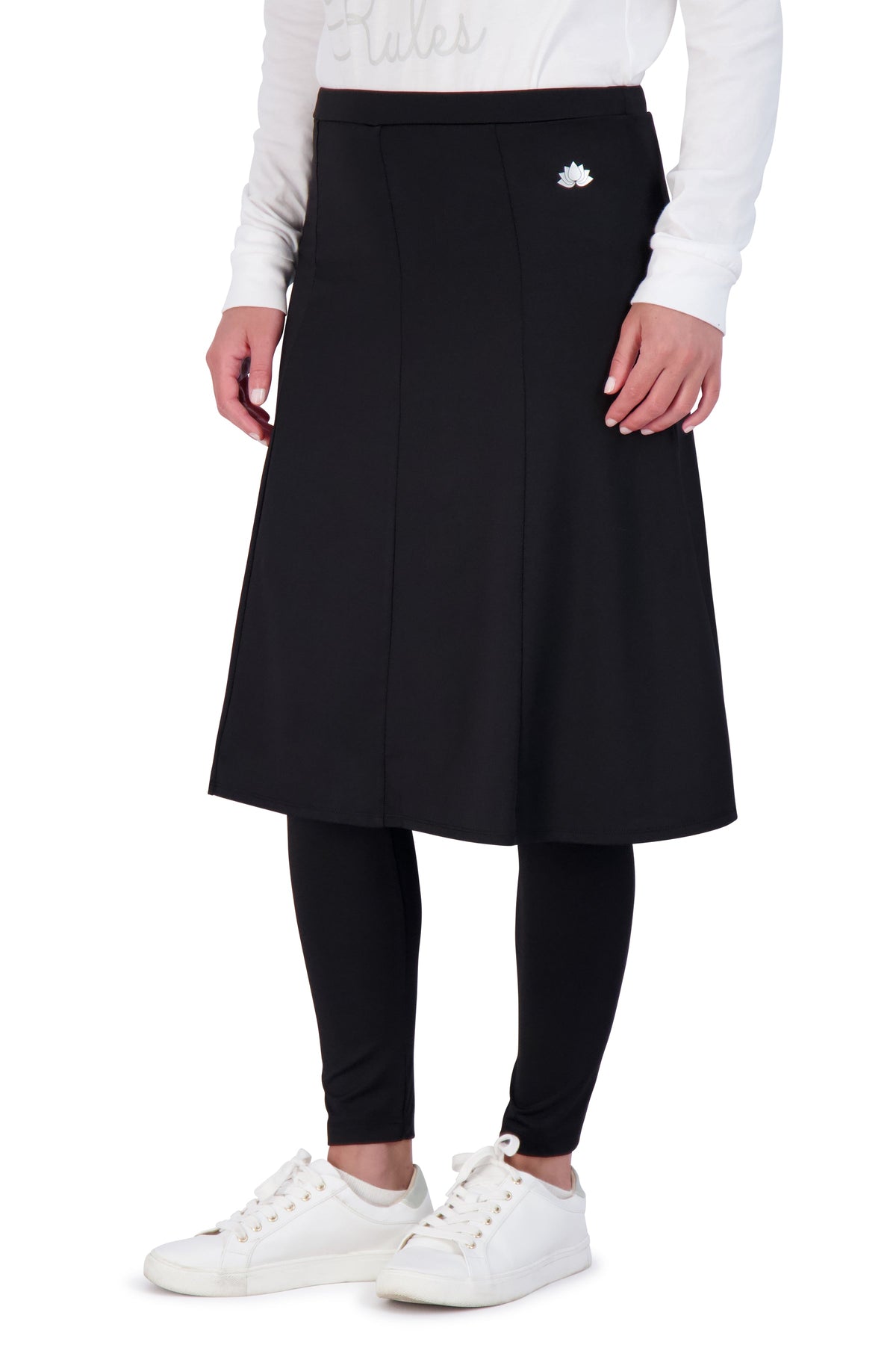 Snoga Athletics black ankle-length modest skirt leggings with lotus logo, worn with white sneakers