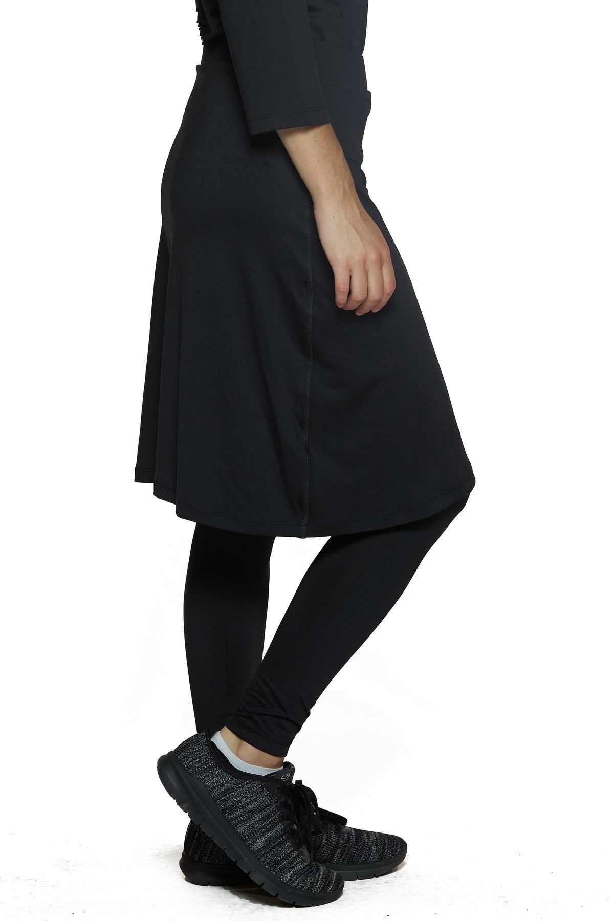 Woman wearing black Snoga Athletics faux wrap skirt with attached leggings and sneakers