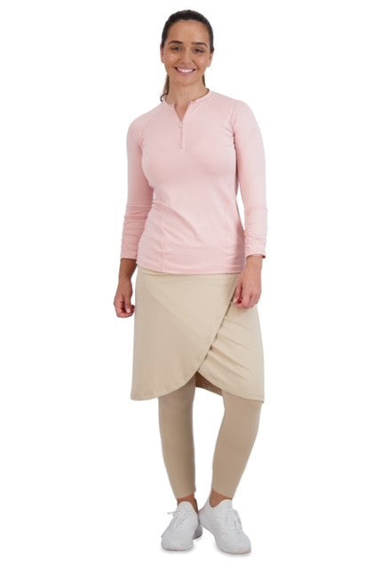 Woman wearing Snoga Athletics ankle faux wrap hummus skirt leggings set with long sleeve pink top