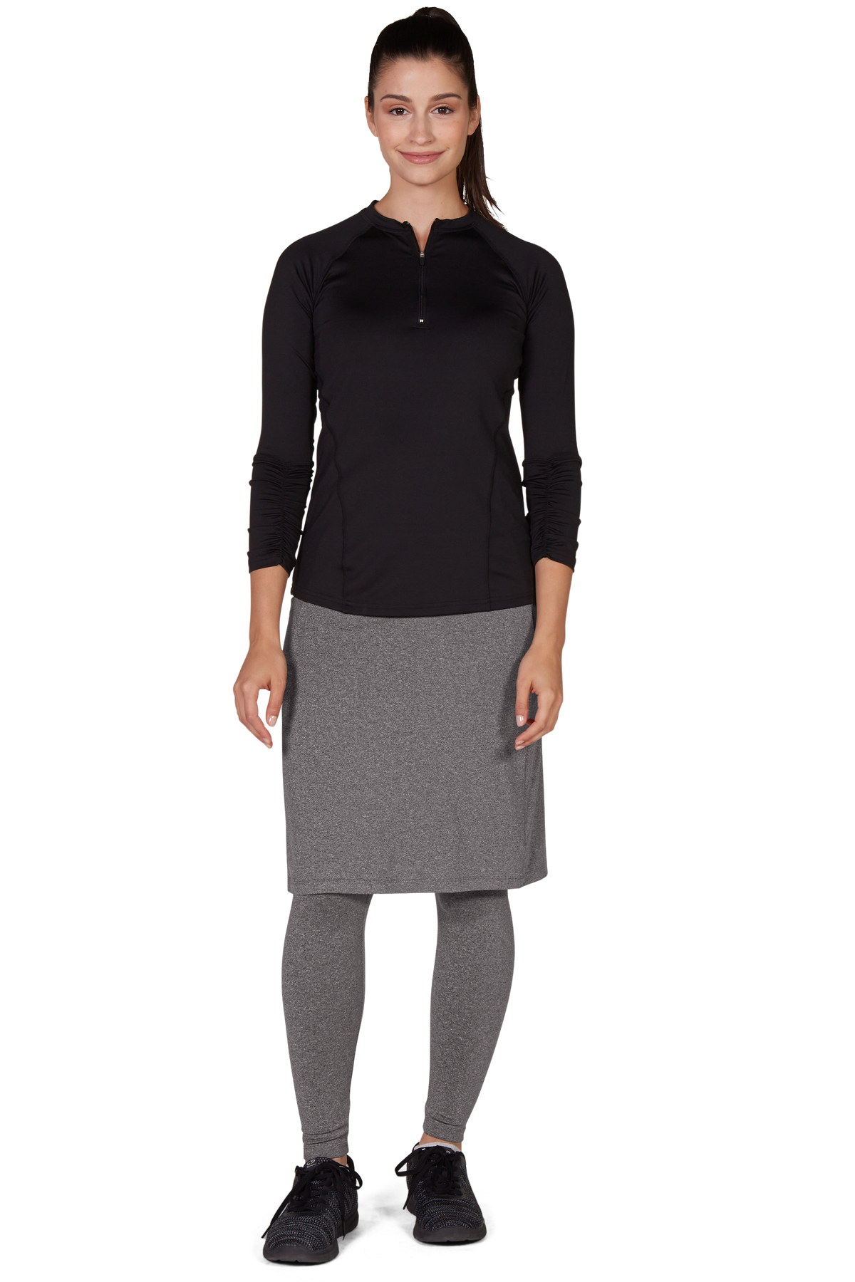Woman in grey ankle-length skirt leggings outfit by Snoga Athletics, black top and sneakers