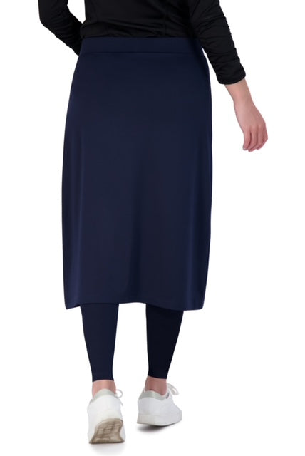 Back view of navy midi skirt with attached leggings by Snoga Athletics, worn with white sneakers.