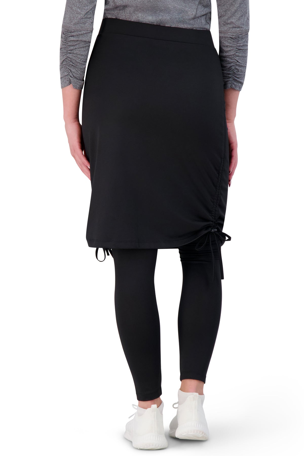 Woman wearing Snoga Athletics black ankle tie side skirt with leggings and white sneakers