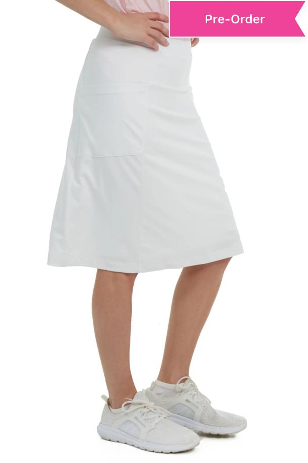 Woman wearing white athletic skort by Snoga Athletics, side view, with sneakers