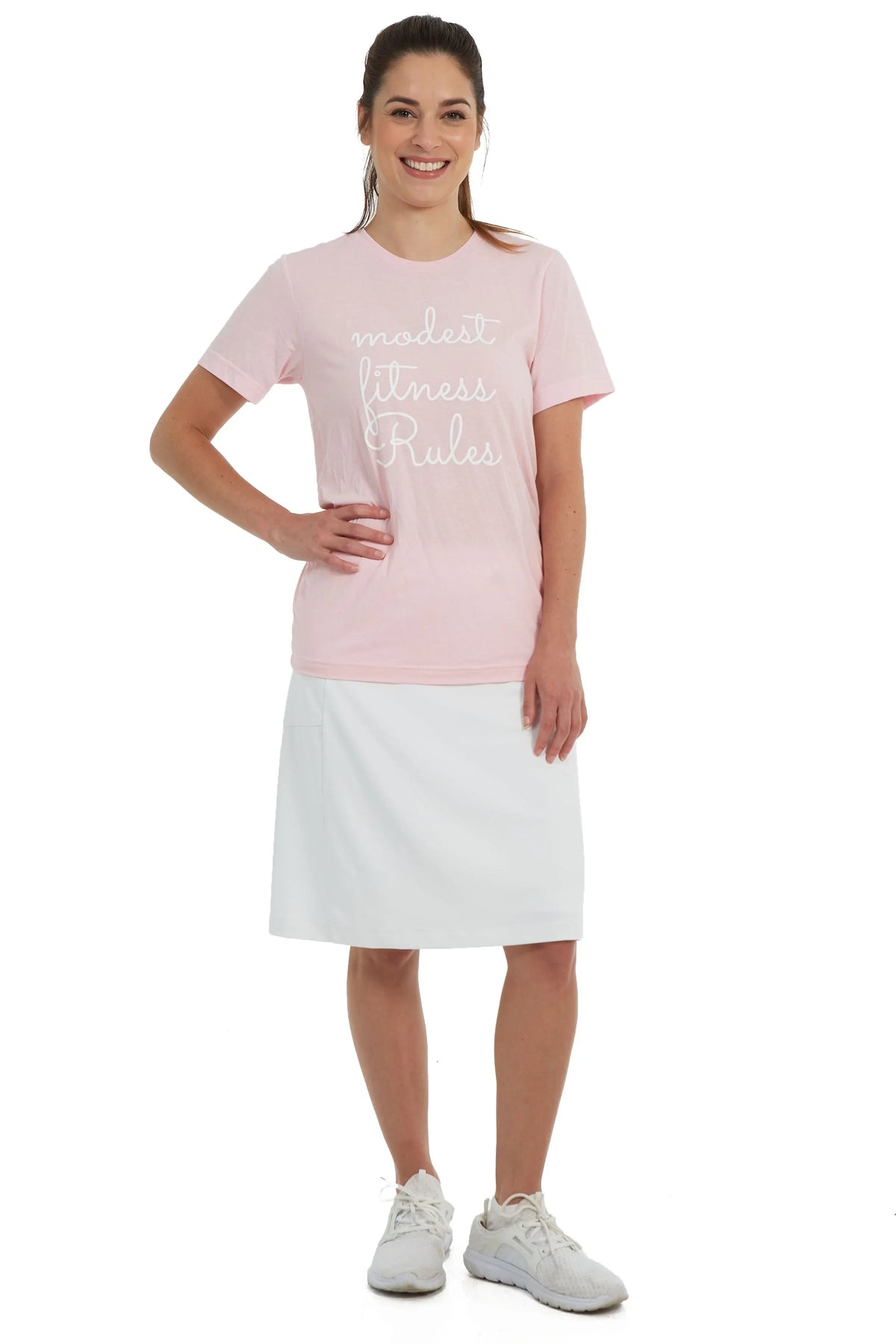 Woman wearing Snoga Athletics modest activewear, pink t-shirt, and white athletic skirt