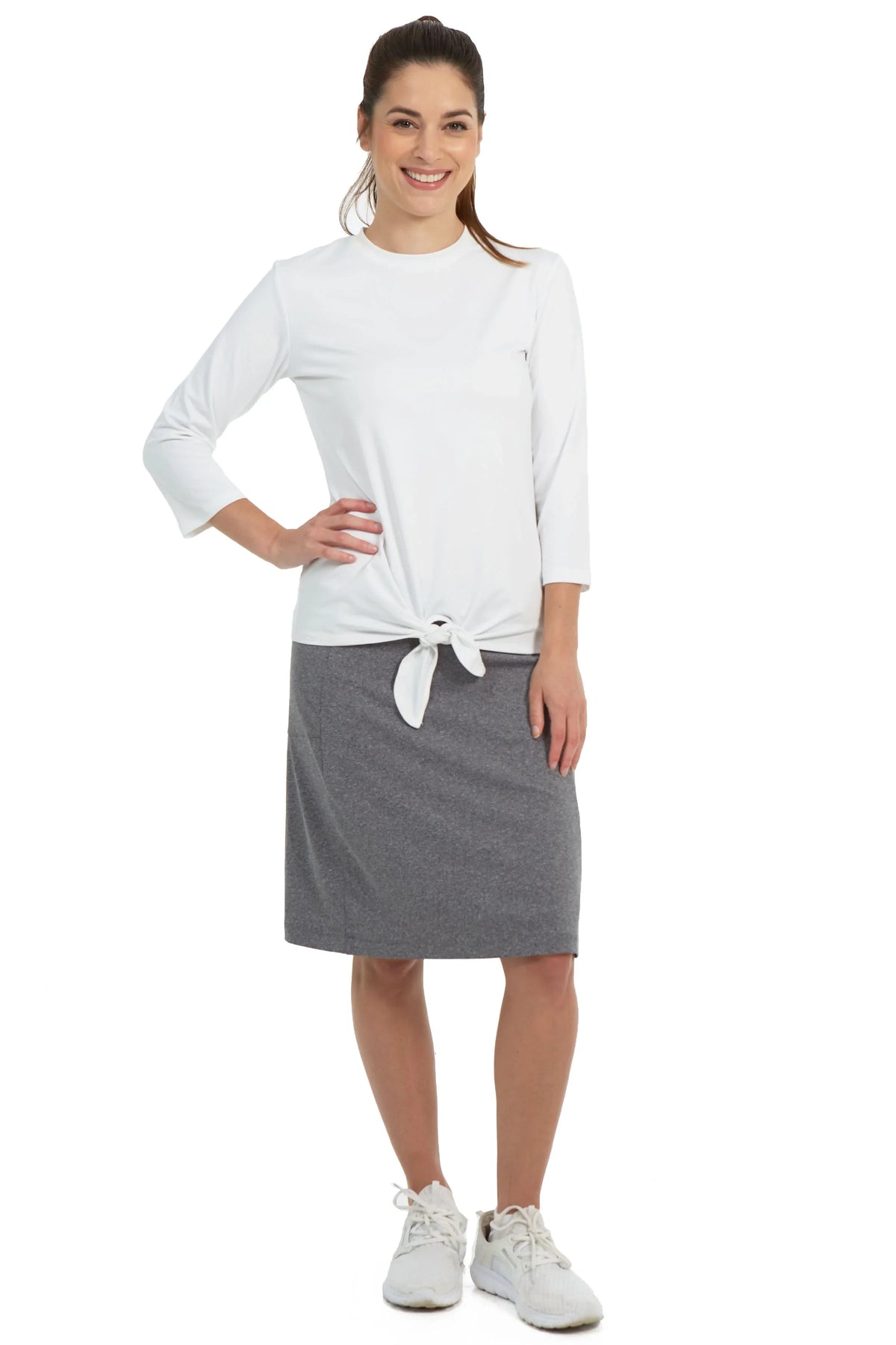 Woman modeling Snoga Athletics heather grey fit skort with white top and sneakers