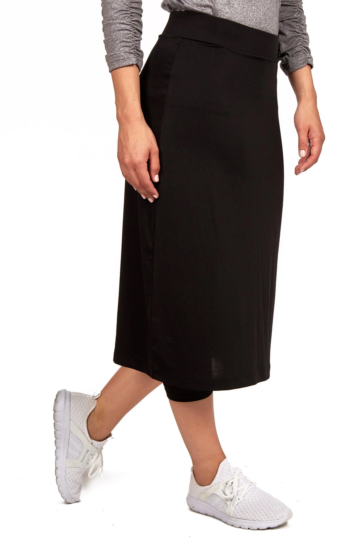 Woman wearing Snoga Athletics black midi active skirt with leggings and white sneakers