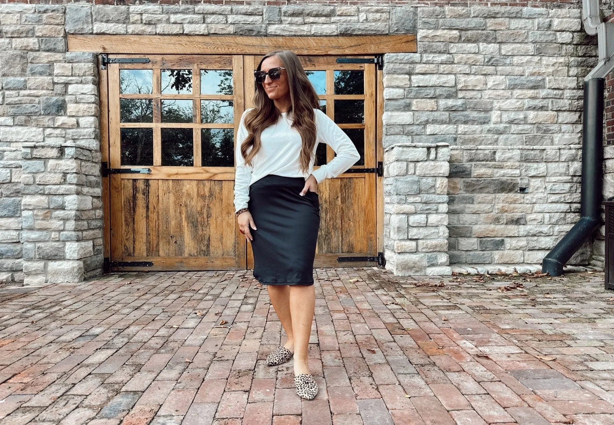 Woman wearing Snoga Athletics black sport pocket skirt and white top outdoors