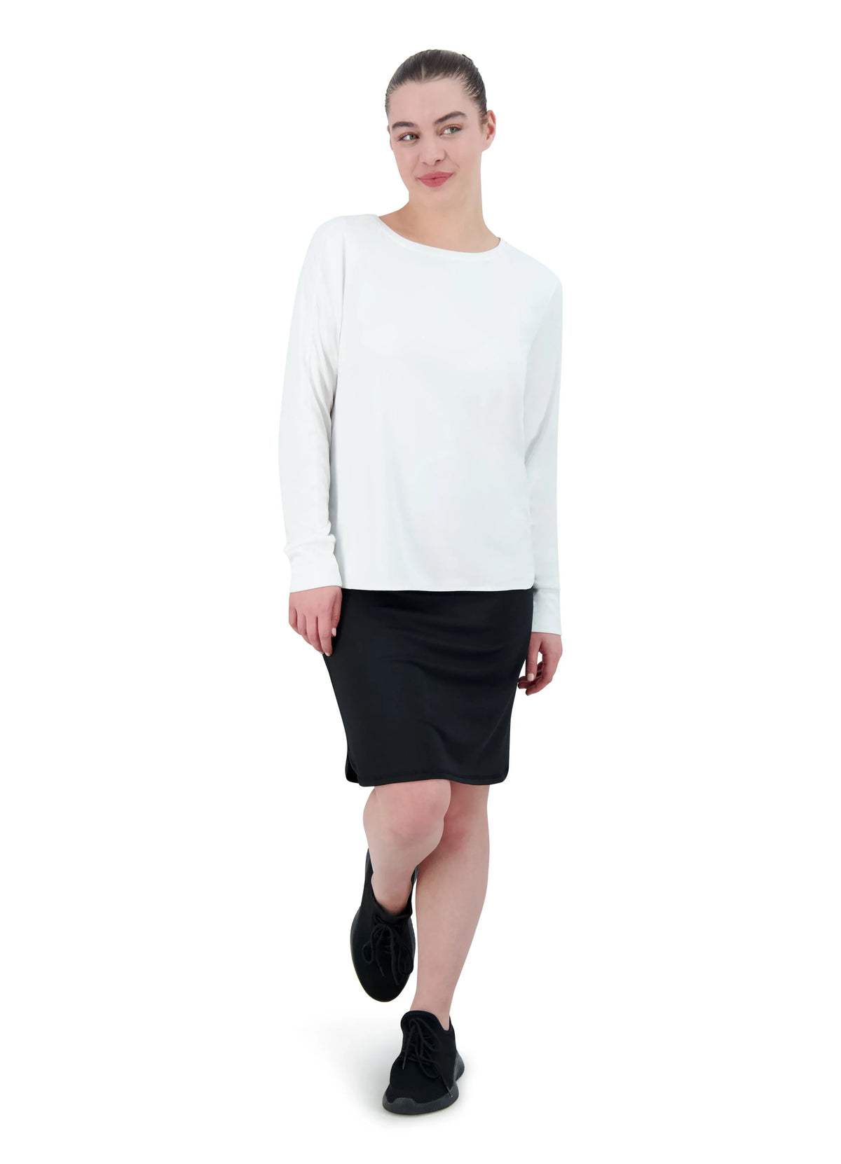 Woman wearing Snoga Athletics black sport pocket skirt and white long sleeve top