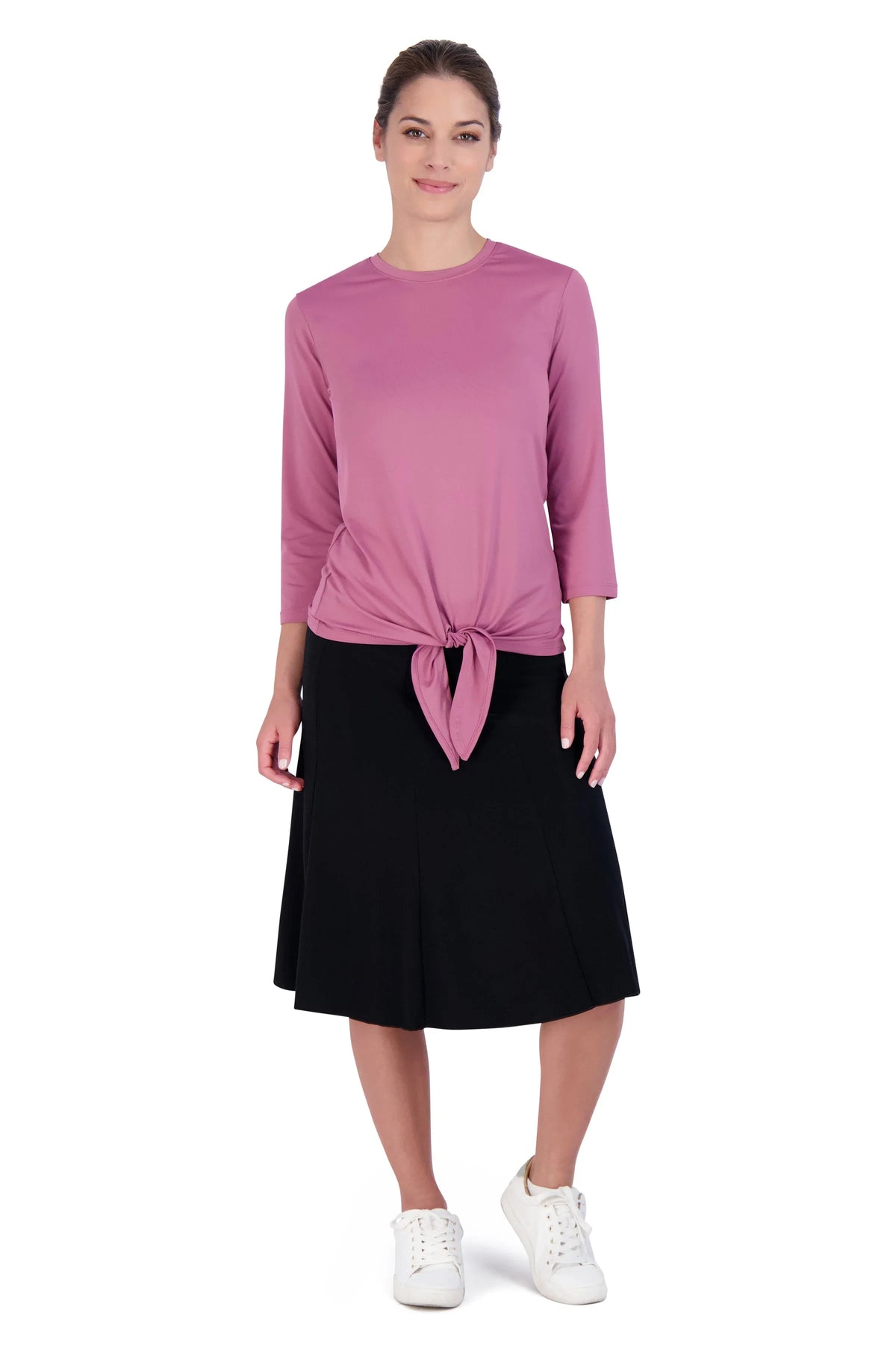 Woman wearing Snoga Athletics black twirly skirt with modest pink tie top and white sneakers