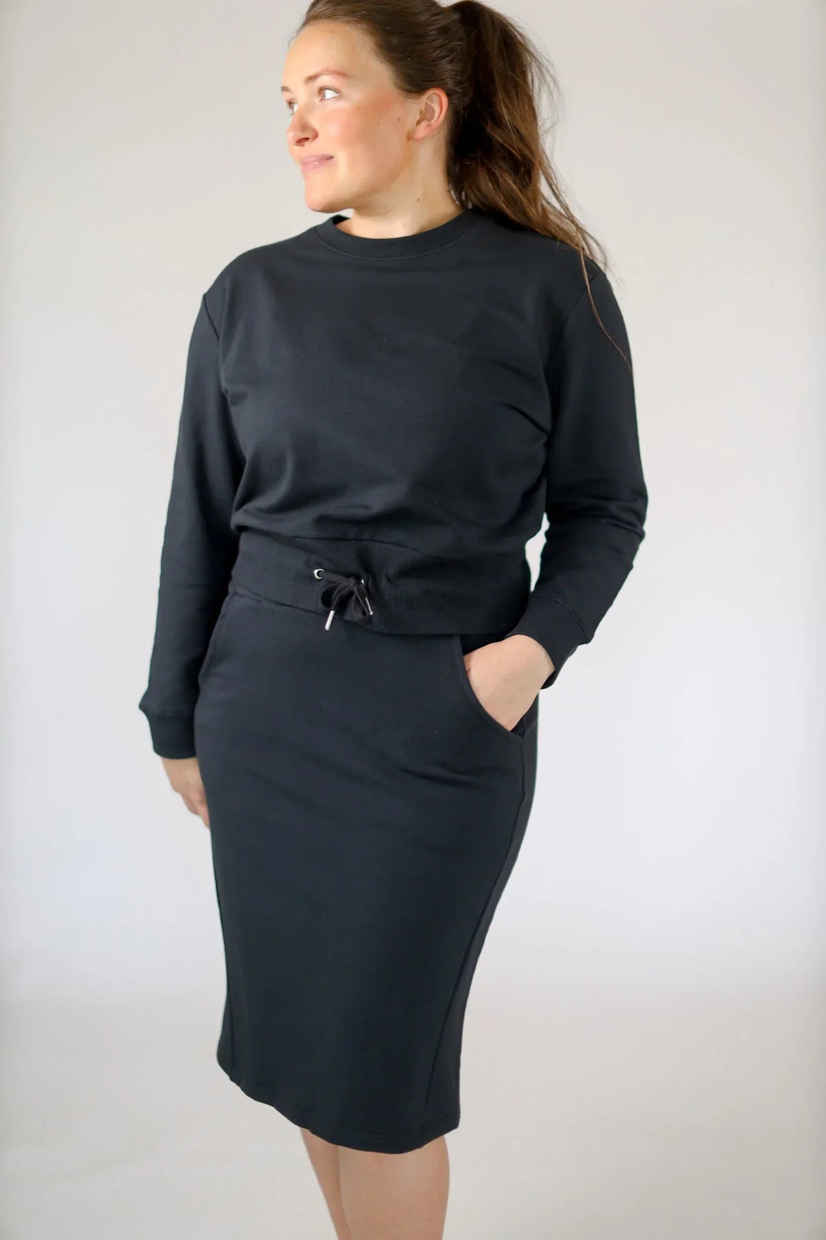 Woman wearing black cropped drawstring pullover sweatshirt by Snoga Athletics