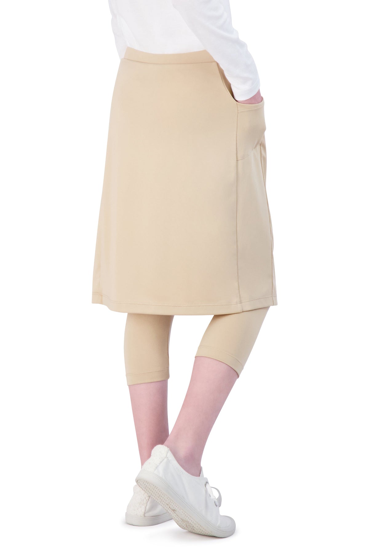 Girl wearing Snoga Athletics tan skirted leggings with side pocket and white sneakers